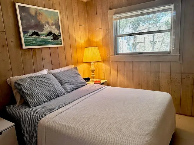 a bedroom with a bed and a painting on the wall