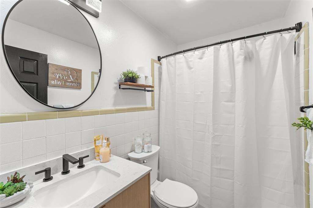 429 Virginia Avenue St. Cloud, FL 34769 - Photo 8 of 41 a bathroom with a sink a toilet and a mirror