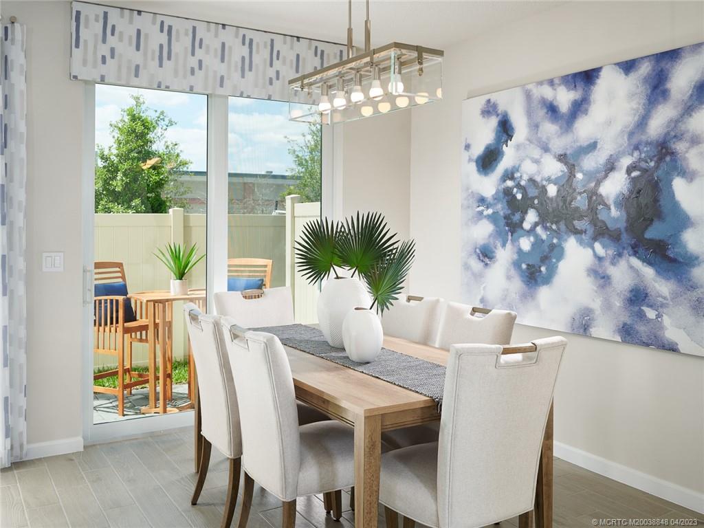 5630 Southeast Edgewater Circle Stuart, FL 34997 - Photo 5 of 9 a dining room with furniture a large window and wooden floor