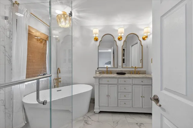 a spacious bathroom with a granite countertop sink a mirror a vanity and a bathtub