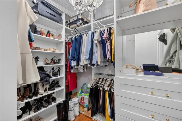 a view of walk in closet with clothes and shoes