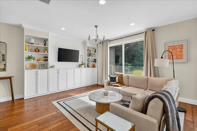 a living room with furniture a flat screen tv and a large window