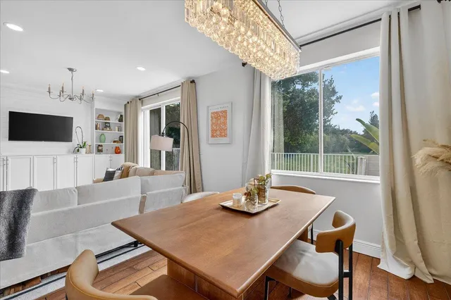 a living room with furniture a flat screen tv and a large window