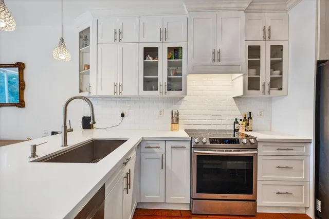 a kitchen with stainless steel appliances granite countertop a stove and a white cabinets