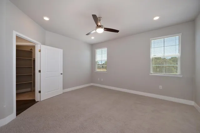 an empty room with closet and windows