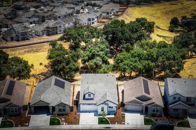 an aerial view of residential houses with outdoor space and swimming pool