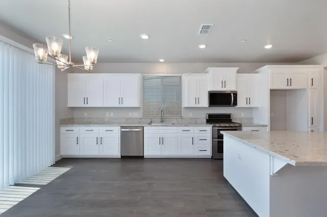 a large kitchen with kitchen island a sink stainless steel appliances and cabinets