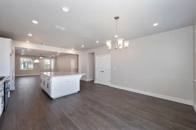 a room with hard wood floors and a chandelier