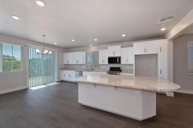 a large kitchen with lots of counter space and stainless steel appliances