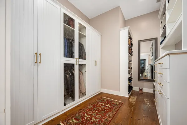 a view of walk in closet with clothes and shoes