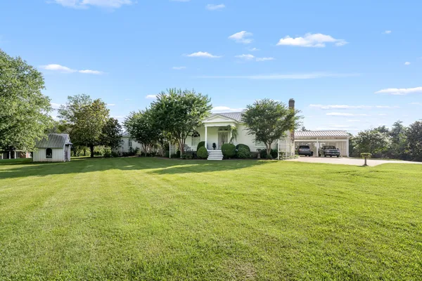 a front view of house with yard and trees