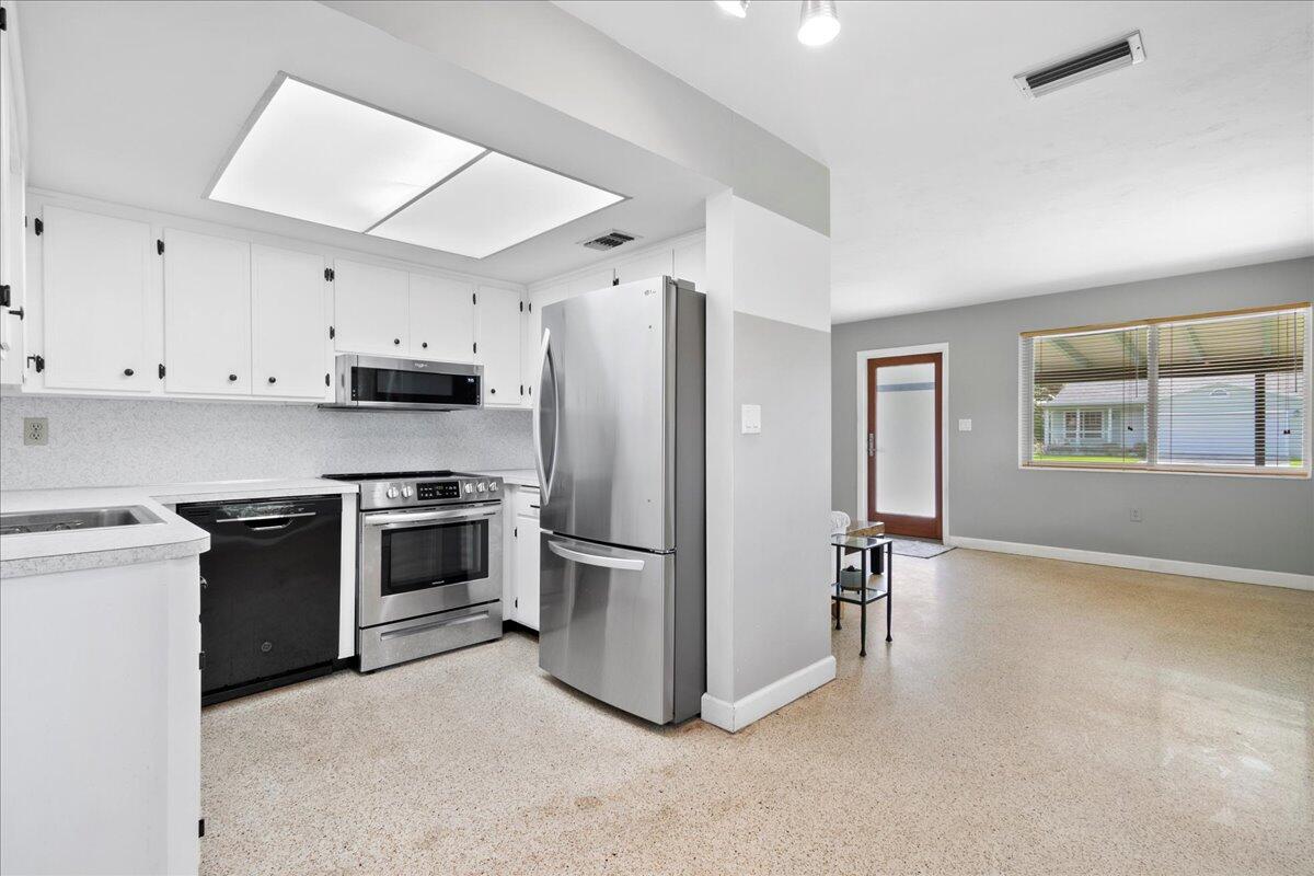 606 Pinegrove Avenue Jupiter, FL 33458 - Photo 4 of 11 a kitchen with stainless steel appliances a refrigerator stove and sink