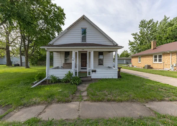 a view of a house with a yard and sitting area