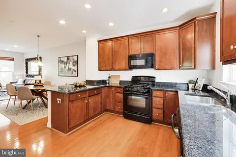 a kitchen with stainless steel appliances granite countertop a stove a sink a microwave and a refrigerator