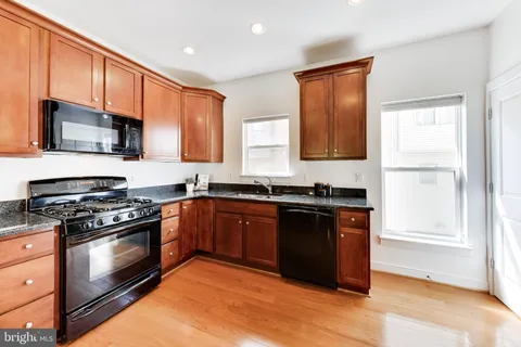 a kitchen with stainless steel appliances granite countertop wooden cabinets stove top oven and sink