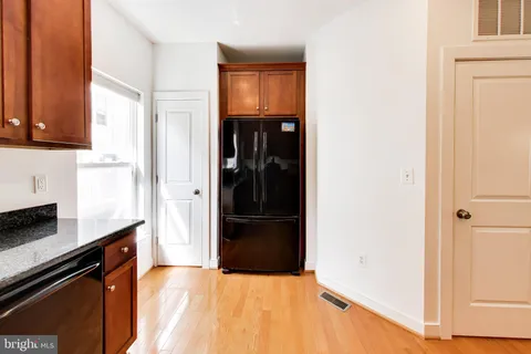 a kitchen with a refrigerator and a stove top oven