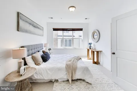a bed room with a bed a mirror and a window