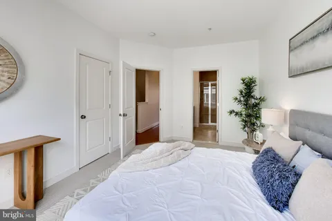 a bedroom with a large bed and a chandelier