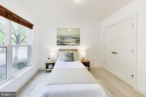 a bedroom with a bed and large window