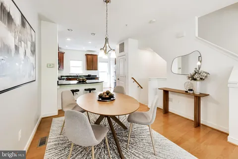 a kitchen with stainless steel appliances kitchen island a table and chairs in it