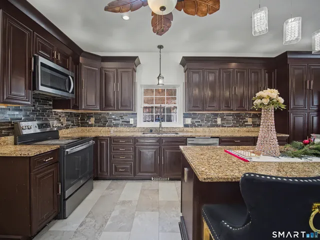 a kitchen with stainless steel appliances granite countertop a sink dishwasher stove and cabinets