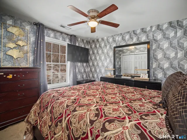 a bedroom with a bed and a large mirror