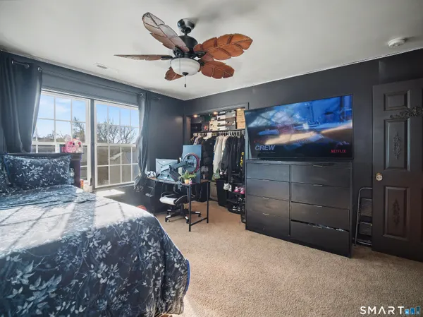 a bedroom with a bed and a large window