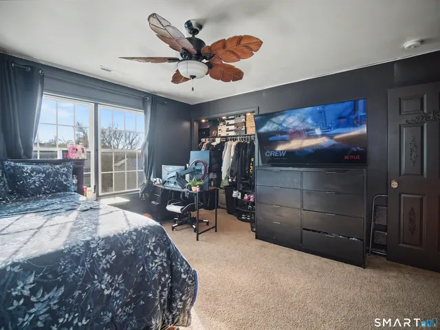 a bedroom with a bed and a large window