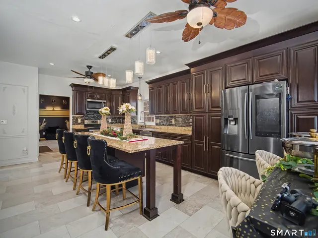 a kitchen with a dining table chairs stainless steel appliances and cabinets