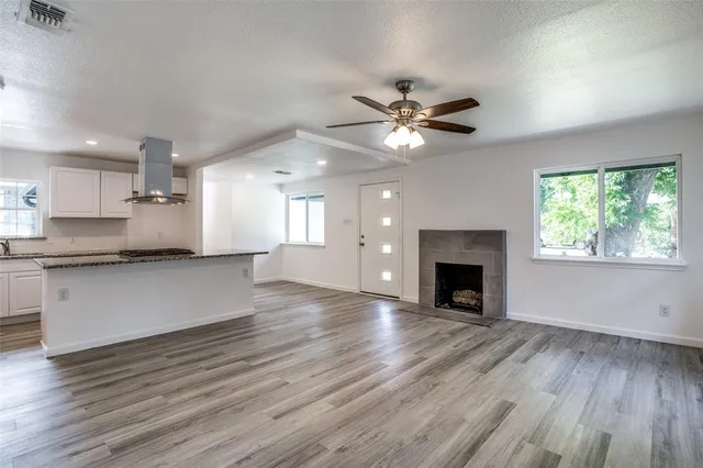 a view of an empty room with a fireplace and a window