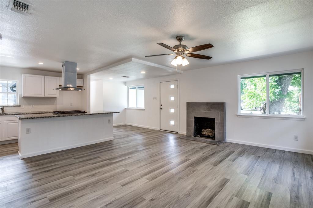 a view of an empty room with a fireplace and a window