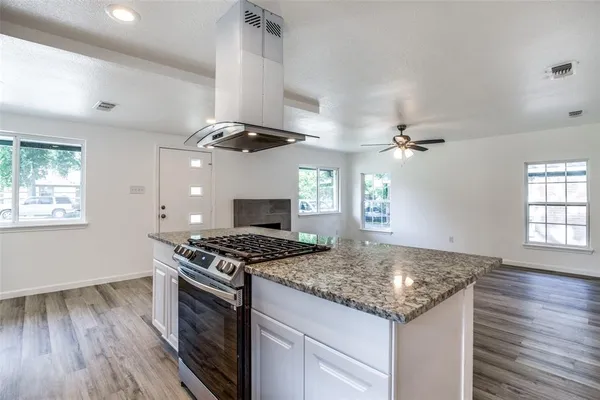 a kitchen with granite countertop a sink a counter space appliances and cabinets