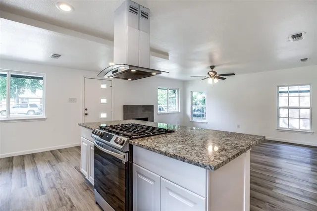 a kitchen with granite countertop a sink a counter space appliances and cabinets