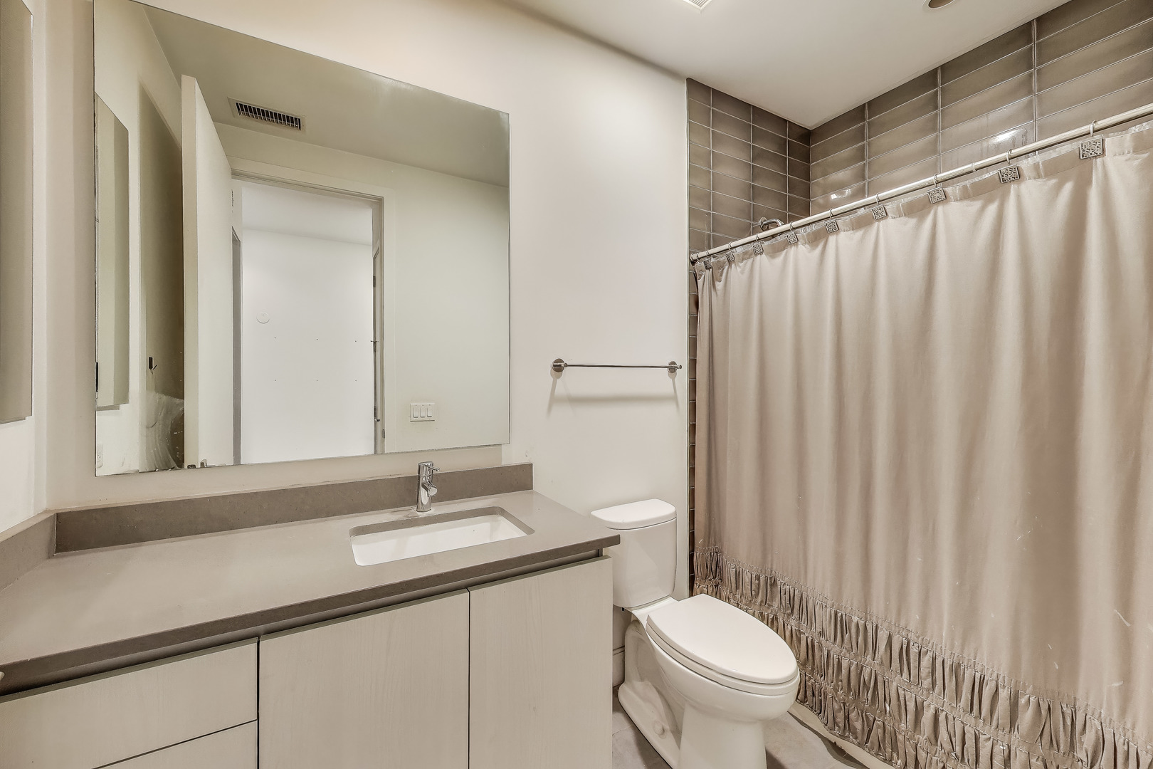 36 North Carpenter Street, Unit 4S Chicago, IL 60607 - Photo 29 of 32 a bathroom with a granite countertop sink a toilet and a mirror