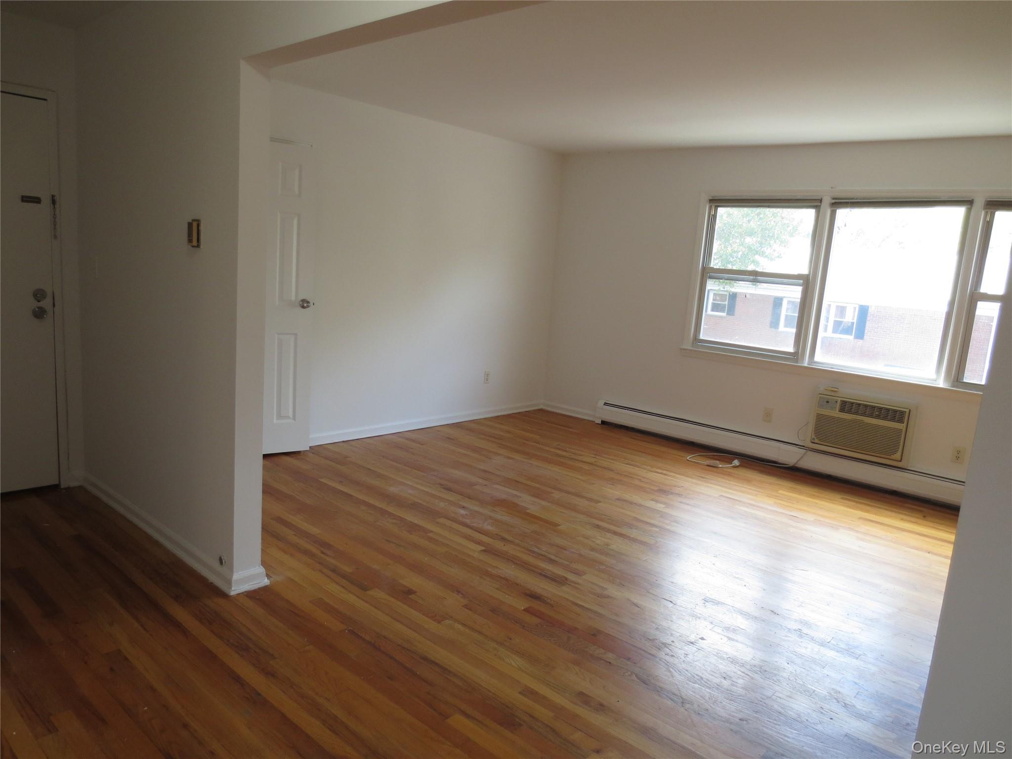 4 Oxford Court, Unit 8007 Suffern, NY 10901 - Photo 7 of 13 Living room light wood finished floors, and a wall unit AC