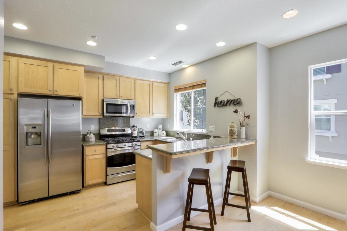 543 Saco Terrace Sunnyvale, CA 94089 - Photo 14 of 50 a kitchen with stainless steel appliances granite countertop a stove a sink a refrigerator white cabinets and wooden floor