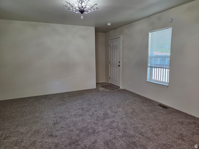 1275 Thrush Road Salt Lake City, UT 84123 - Photo 4 of 20 Neutral-toned carpet flooring, light wall paint, and a decorative ceiling light fixture