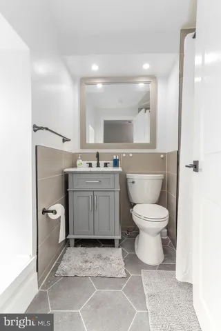 a bathroom with a toilet sink and mirror