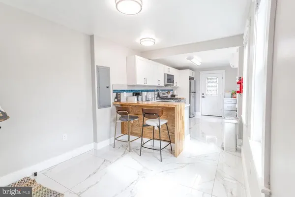 a kitchen with stainless steel appliances kitchen island granite countertop a refrigerator and a sink
