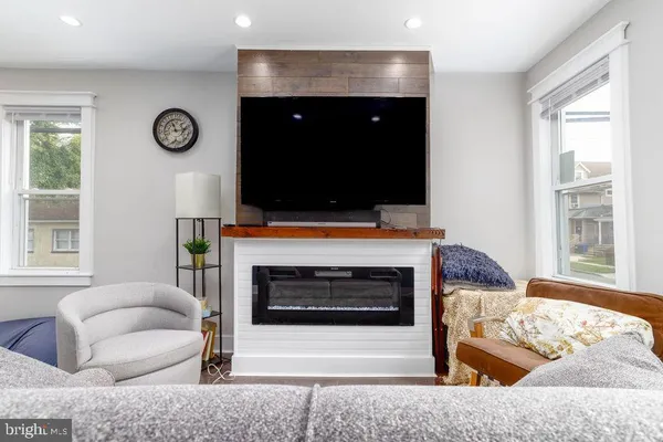 a living room with furniture a flat screen tv and a fireplace