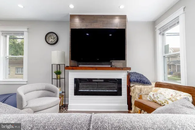 a living room with furniture a flat screen tv and a fireplace