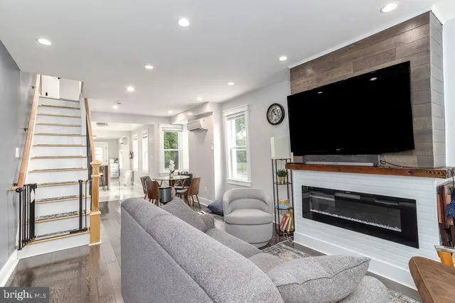 a living room with furniture a flat screen tv and a fireplace