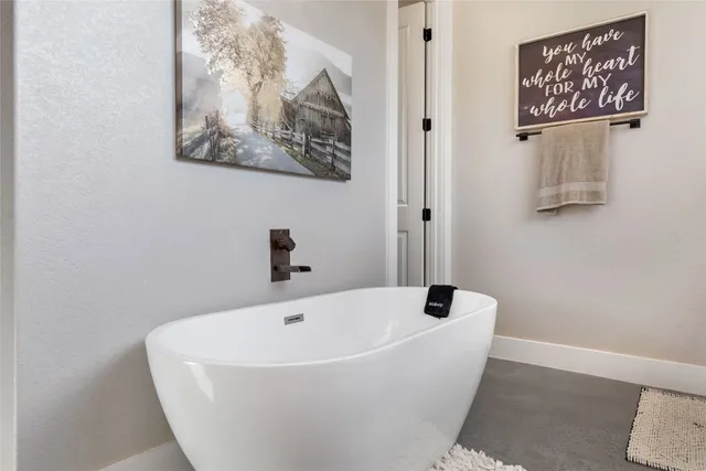 a white bath tub sitting next to a white wall