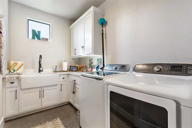 a utility room with sink dryer and washer