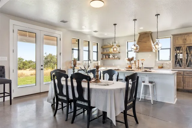 a view of a dining room and livingroom with furniture wooden floor a chandelier