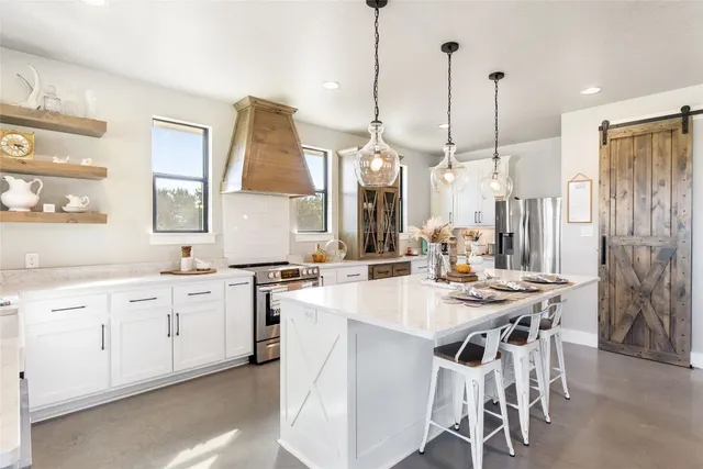 a kitchen with center island table and chairs