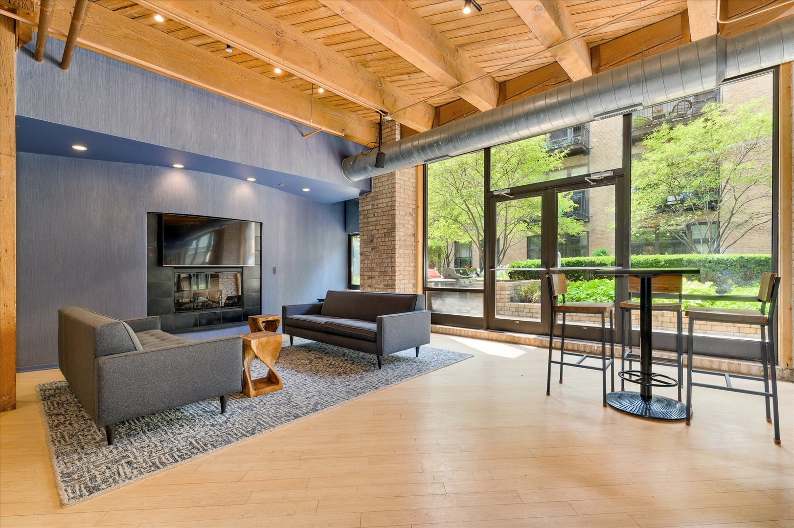 1040 West Adams Street, Unit 336 Chicago, IL 60607 - Photo 21 of 23 a living room with furniture a flat screen tv and a floor to ceiling window