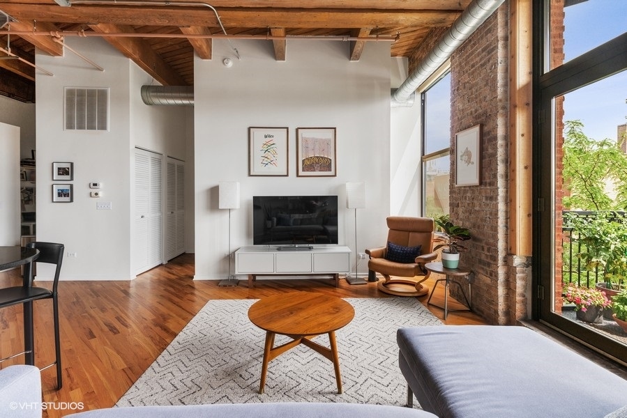1040 West Adams Street, Unit 336 Chicago, IL 60607 - Photo 5 of 23 a living room with furniture and a flat screen tv