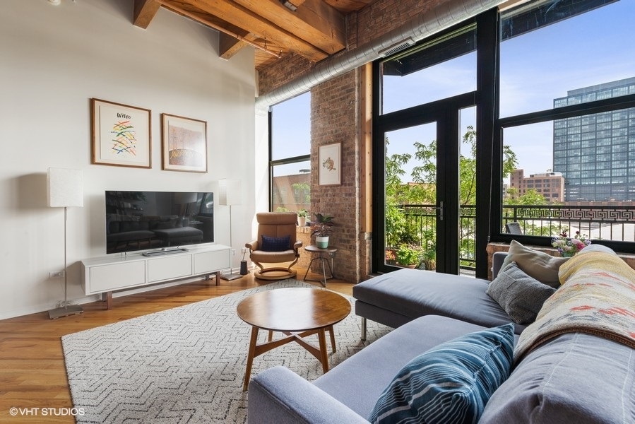 1040 West Adams Street, Unit 336 Chicago, IL 60607 - Photo 6 of 23 a living room with furniture a flat screen tv and a large window