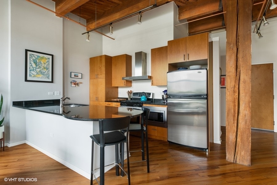 1040 West Adams Street, Unit 336 Chicago, IL 60607 - Photo 7 of 23 a kitchen with stainless steel appliances a refrigerator and a stove top oven
